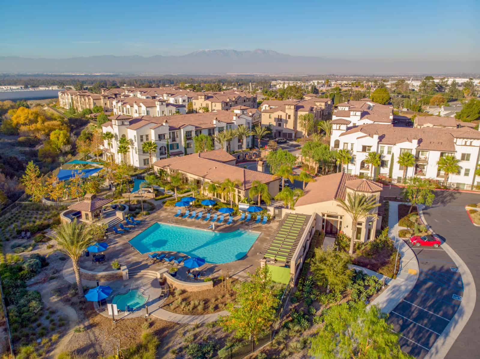 drone photo of residential apartment complex with swimming pool in foreground in Corona, California